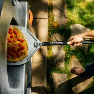 Fontana Forni Mangiafuoco Pizza Oven Lifestyle image top down showing inserting pizza