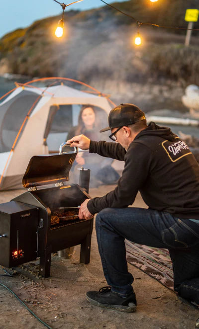 Green Mountain Grill - Trek Prime Stainless Wood Pellet Smoker - Stainless Steel.  Family on Beach cooking.  The Outdoor Grill Company.